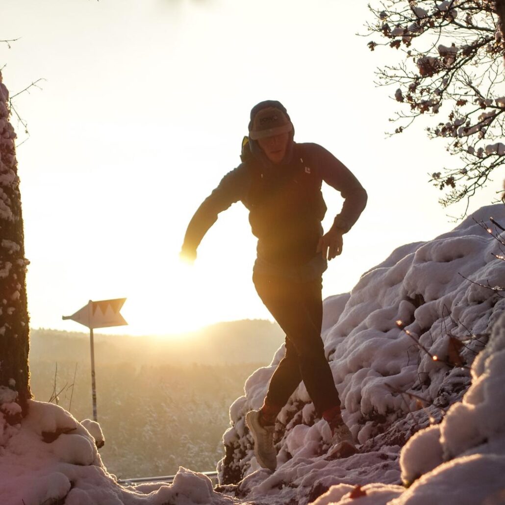 Ein Läufer in einer hügeligen Schneelandschaft