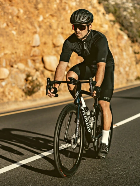 Mann in schwarzer Rennradbekleidung auf Rennrad