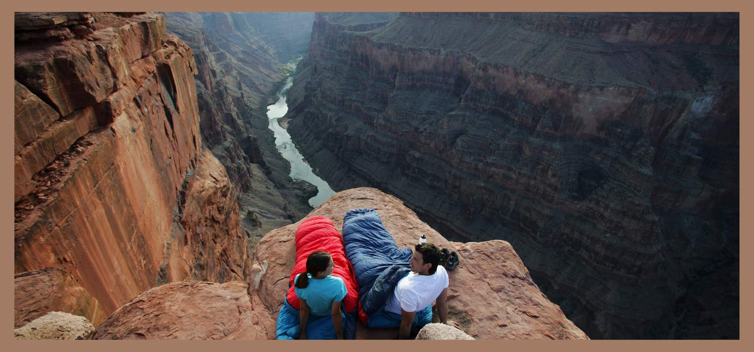 Mann und Frau mit Schlafsack im Canyon