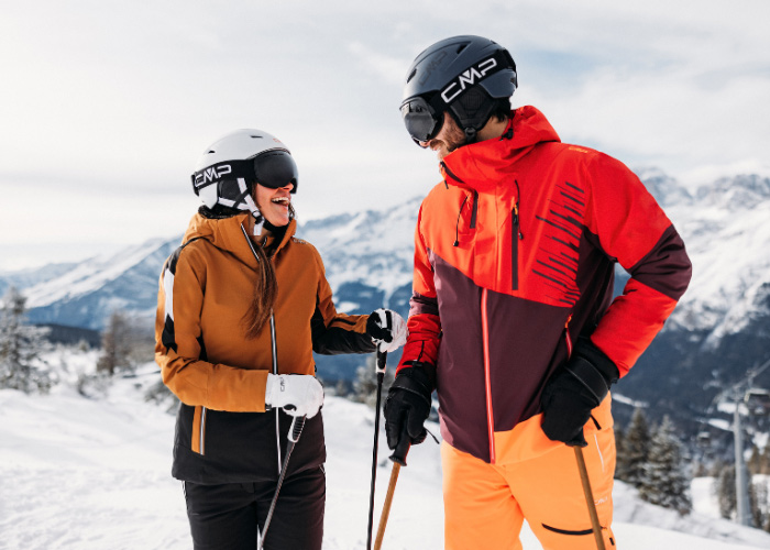 Mann und Frau in Skibekleidung mit Helm und Brille