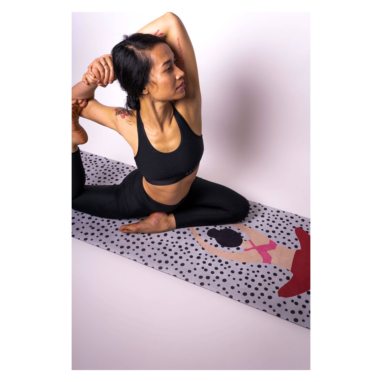Yogi-in-gebundener-Haltung-auf-gepunkteter-Yogamatte