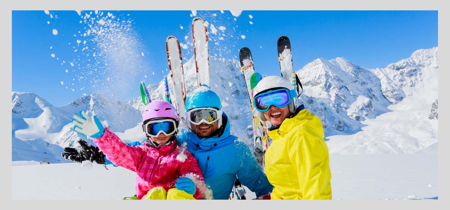 Froehliche Ski Familie in den Bergen